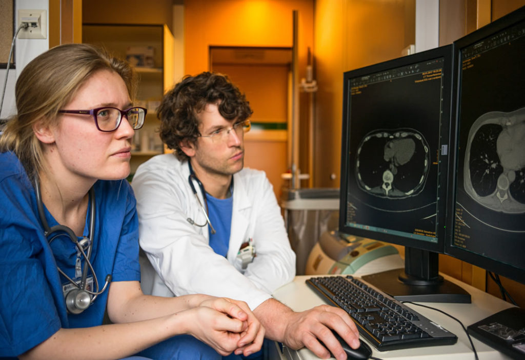two-medical-technicians-reviewing-an-mri-on-a-computer-monitor